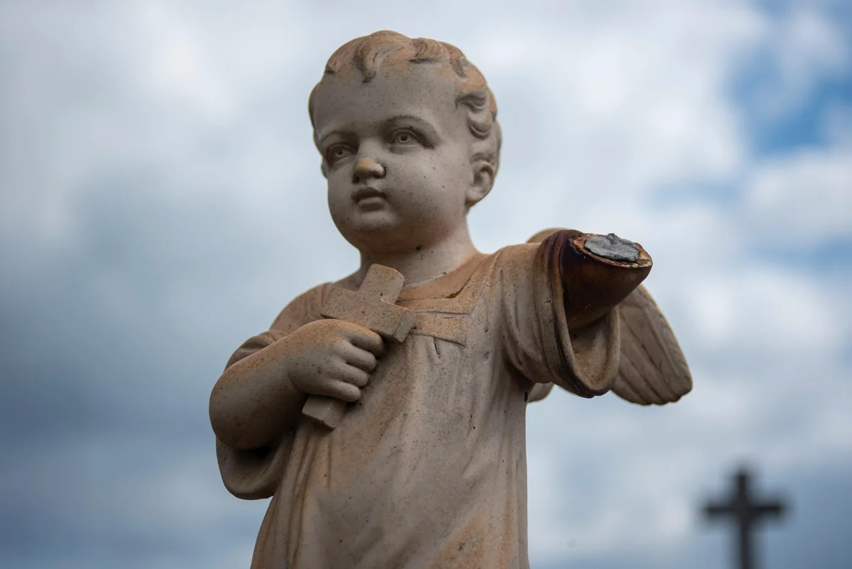 A weathered angel statue among the graves
