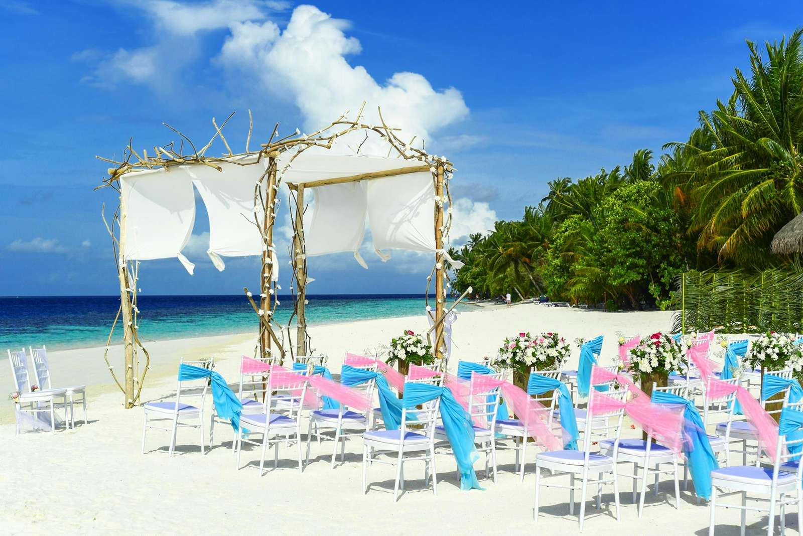 Beach wedding setup with floral arch on a Key West tropical beach