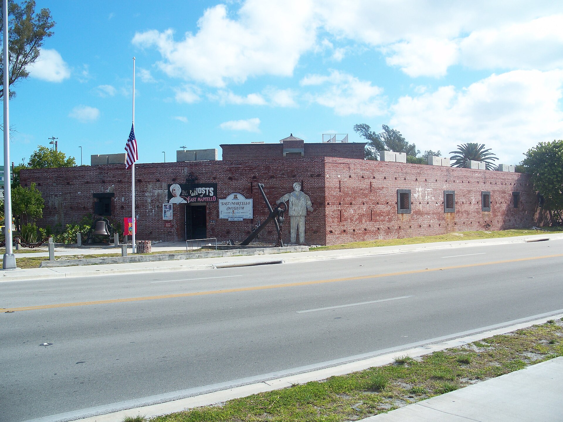 The red-brick walls of Fort East Martello museum in Key West with a Ghosts of East Martello sign featuring Robert the Doll