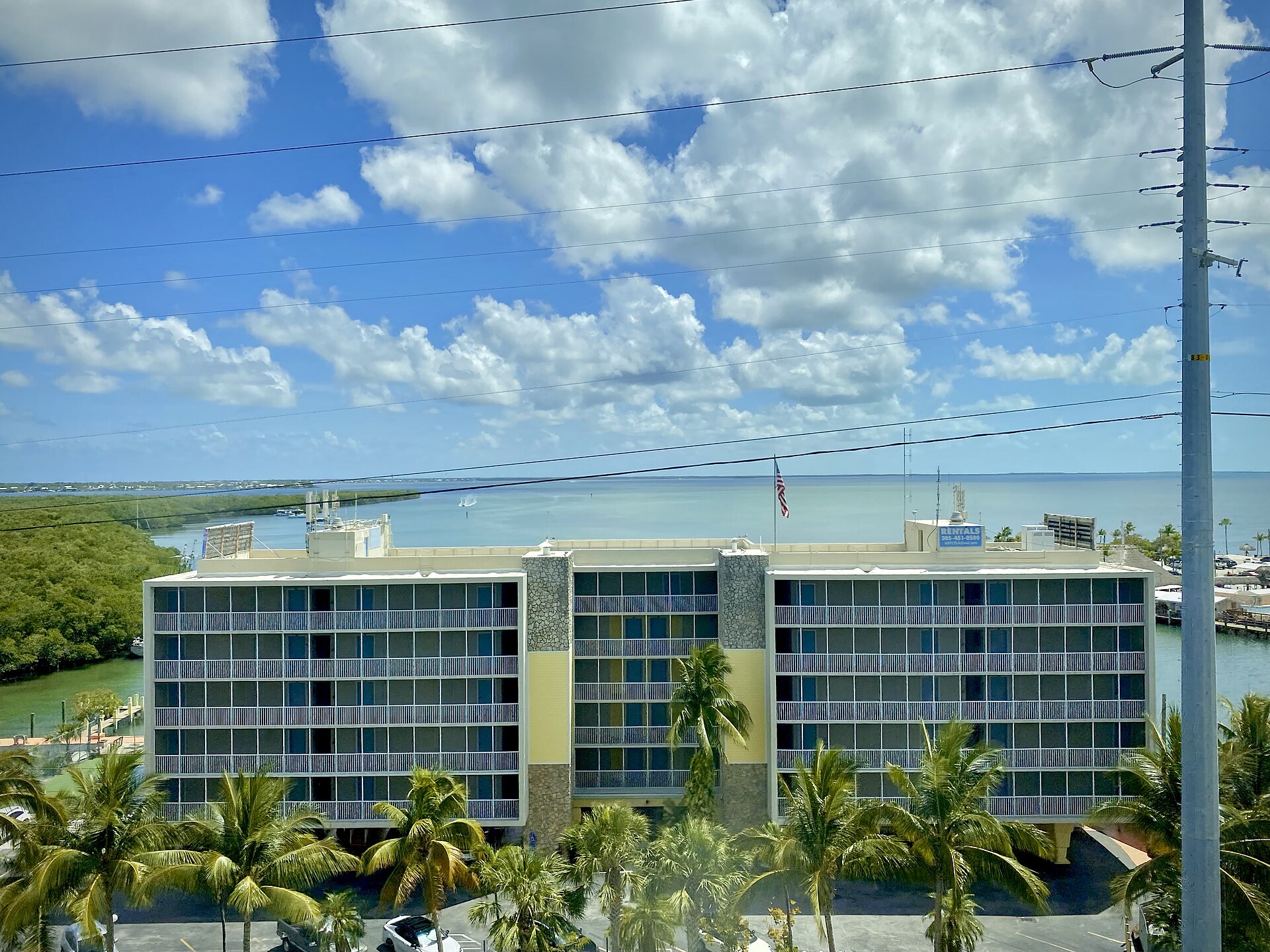 A six-story waterfront resort building on Blackwater Sound in Key Largo with mangroves and open bay water behind it