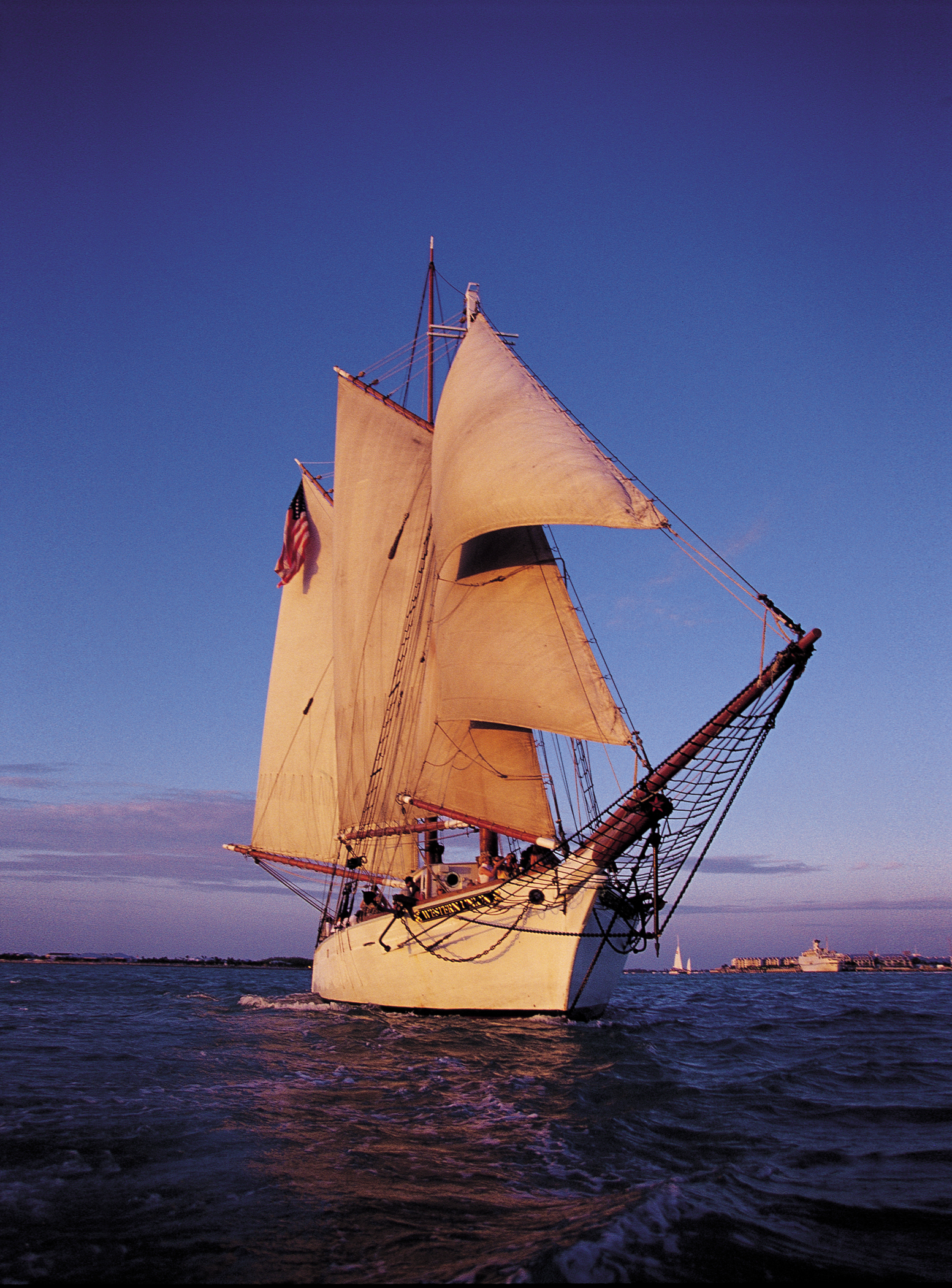 The historic schooner Western Union under full sail in golden evening light off Key West