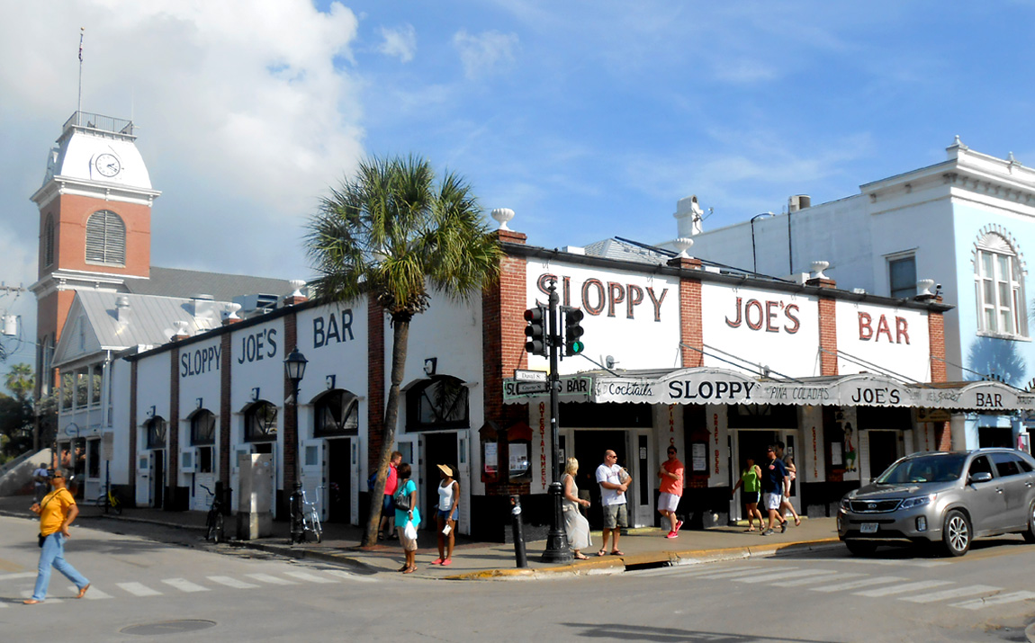 The white brick corner building of Sloppy Joe's Bar on Duval Street in Key West with its name painted along the top